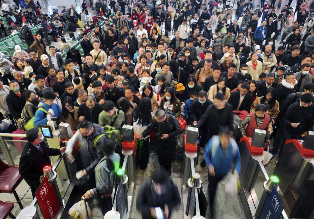 4月6日，在铁路湖南衡阳东站候车室，旅客排队过闸机进站（无人机照片）。新华社发（曹正平 摄）