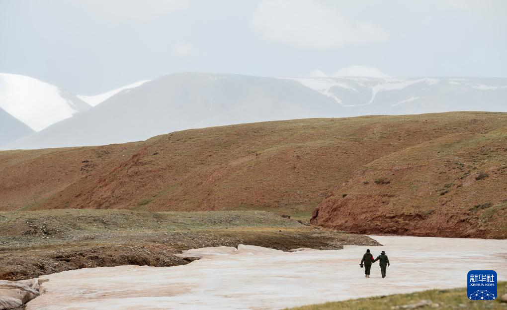 6月15日，羌塘国家级自然保护区野生动物专业管护队员索朗（右）和罗布检查河面冰冻情况。新华社记者 费茂华 摄