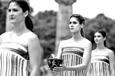 4月16日,一名扮演女祭司的演员手捧火种罐