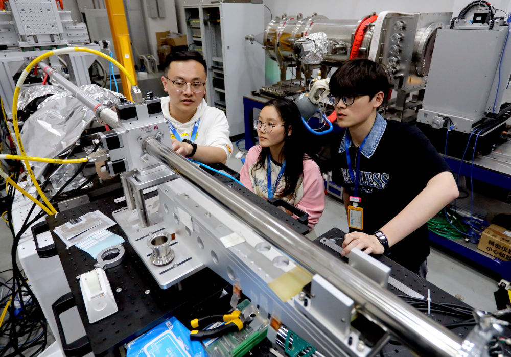2024年4月10日，安徽省先进功能高分子薄膜工程实验室团队成员朱健和（左）在上海同步辐射光源实验线站向团队成员讲解实验设备运行情况。