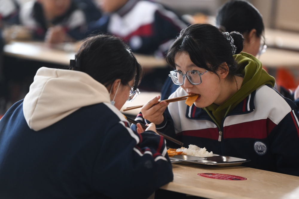 2023年2月23日，果洛西宁民族中学学生在食堂吃午饭。
