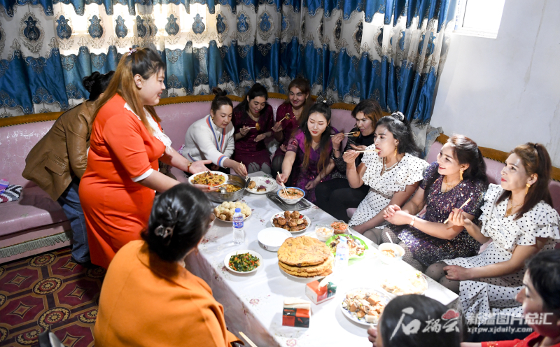 和田地区皮山县木奎拉乡康达库勒村妇女相聚在一起品美食、拉家常(拍摄于2023年3月)。石榴云/新疆日报记者 拍热扎提·阿不都 摄