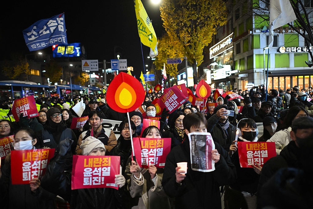 当地时间2024年12月4日，韩国首尔，抗议者们参与反对韩国总统尹锡悦的游行，向总统府进发。视觉中国 图