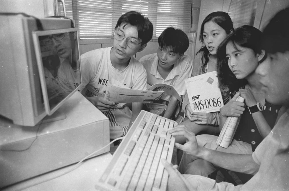 1994年,杭州中学生李勇明(左)在家办起了电脑兴趣小组,每天都有许多同学来他家调试自己设计的程序。