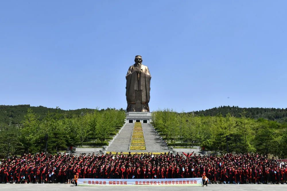 在曲阜市尼山圣境，来自济南市章丘双语学校的同学参加研学活动并在孔子像前合影留念。新华社记者 郭绪雷 摄