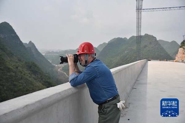 法国摄影师格雷瓜尔·戴高乐在花江峡谷大桥施工现场拍摄（4月27日摄）。新华社记者 骆飞 摄