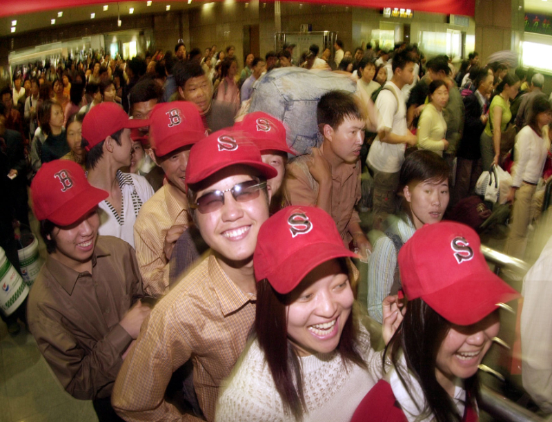 2004年5月1日，在杭州火车站出口处，大批旅行团游客准备出站。“五一”期间，来自全国各地的大批游人通过铁路和公路涌入杭州，形成旅游高峰。新华社发（李震宇 摄）
