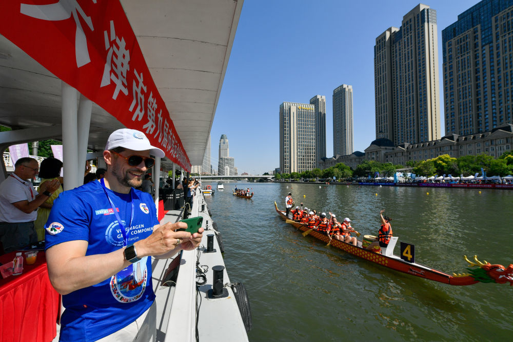 在天津海河利顺德码头，外国友人观看龙舟比赛。