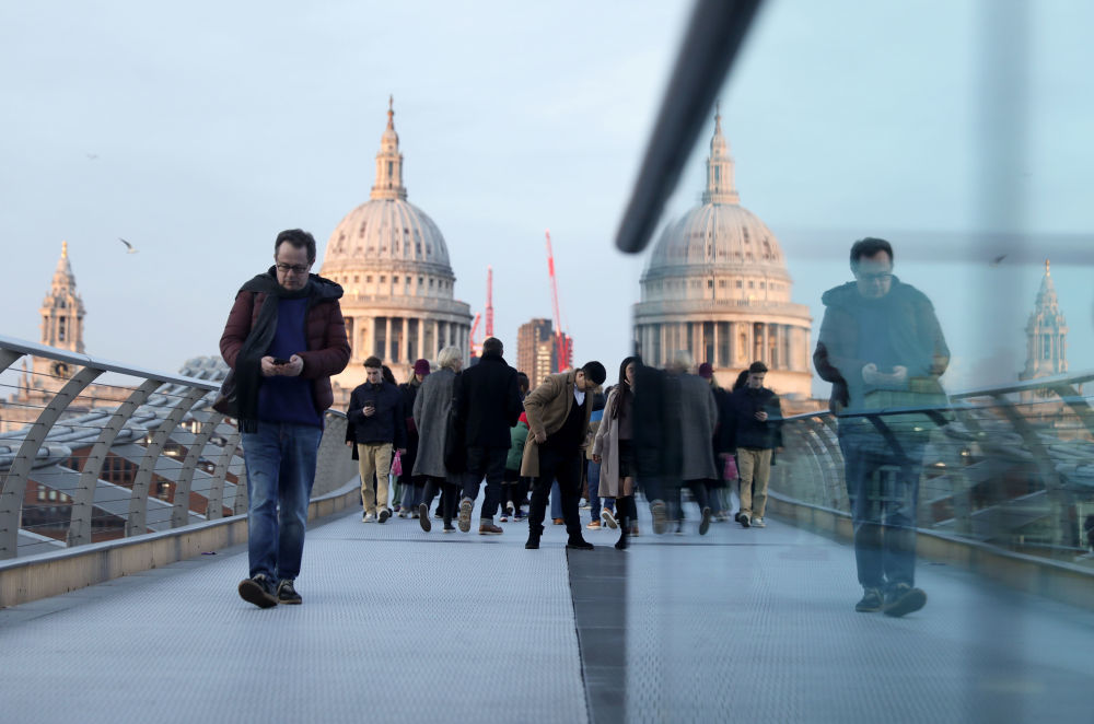 人们在英国伦敦横跨泰晤士河的千禧桥上行走。