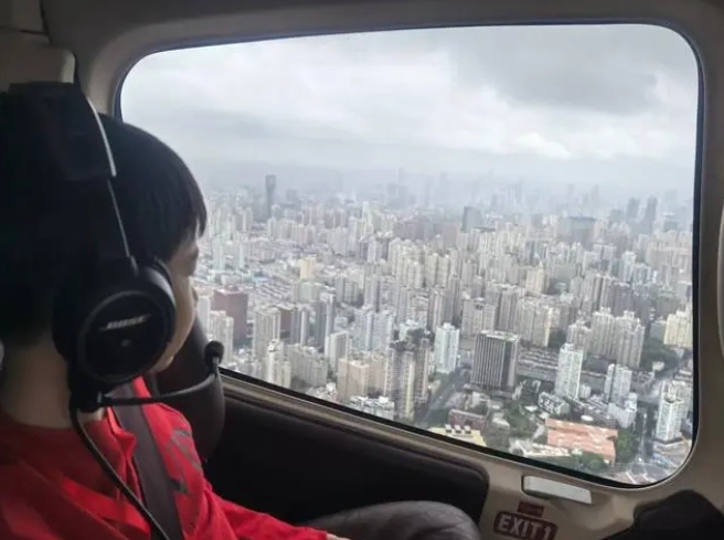 10月1日，上海新空直升机有限公司新增黄浦江低空旅游项目，首批乘客中的一名男孩在欣赏窗外风景。新华社发