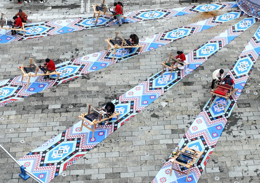 织锦女工在来凤县龙凤文化中心广场现场制作西兰卡普，展示非遗技艺（2023年10月28日摄，无人机照片）。