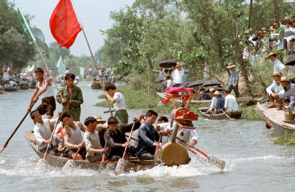 1985年，人们在浙江杭州城外大运河上参与龙舟竞渡。