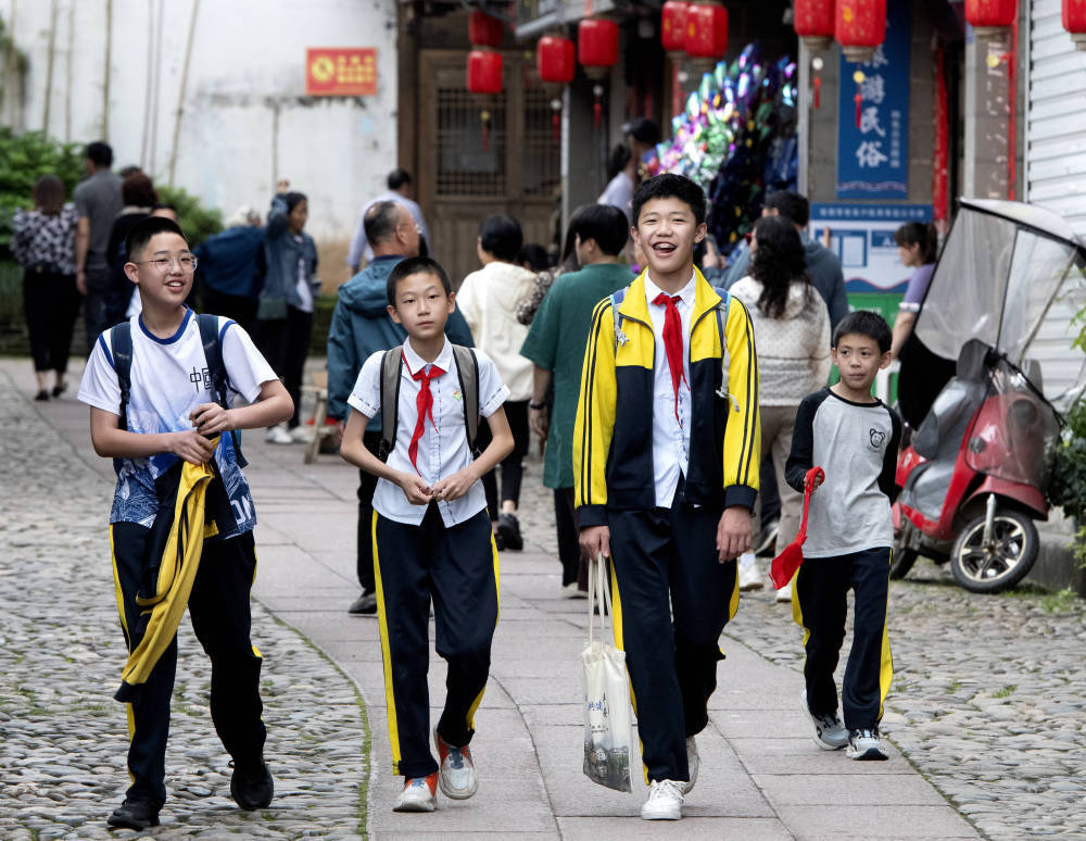 小学生们放学经过泰宁县尚书巷历史文化街区（4月19日摄）。