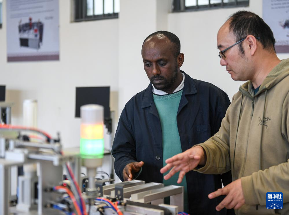 2月15日,在亚的斯亚贝巴的埃塞俄比亚联邦职业技术培训学院,鲁班工坊中方负责人江绛(右)与当地教师约纳斯·阿凯莱(中文名艾友涵)交流教学内容。