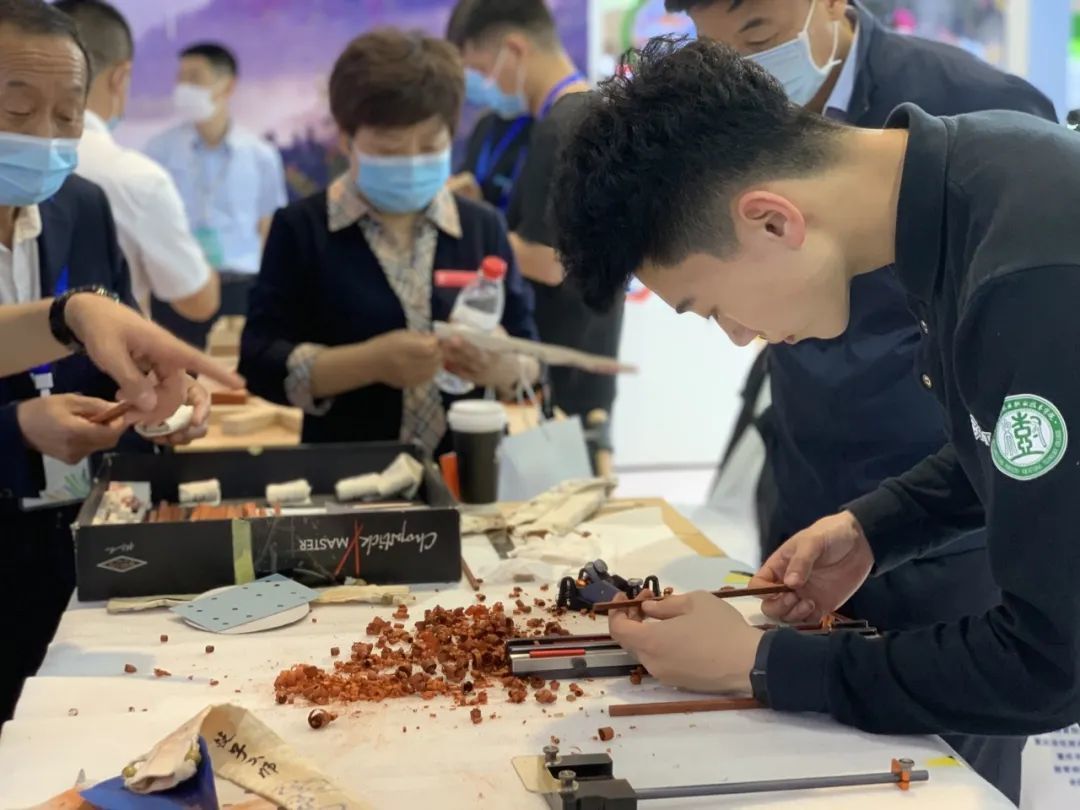 黑龙江林业职业技术学院学生在全国职教博览会上制作红木筷子。黑龙江省教育厅供图