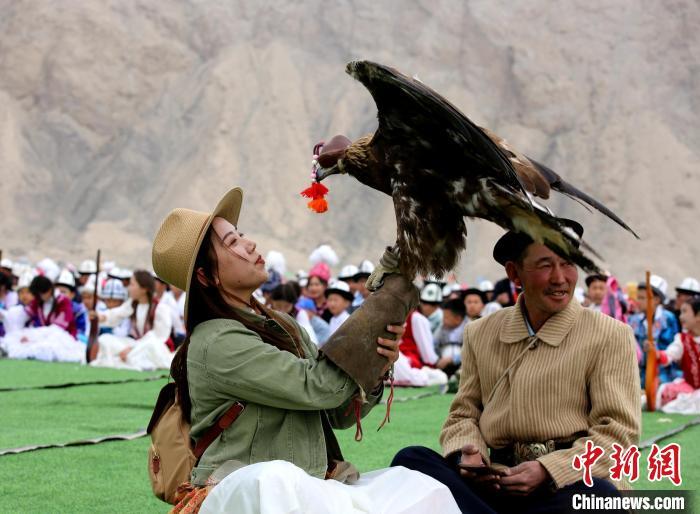 近日，2024年新疆阿合奇县猎鹰文化旅游季拉开帷幕，游客现场与猎鹰互动。陶拴科 摄
