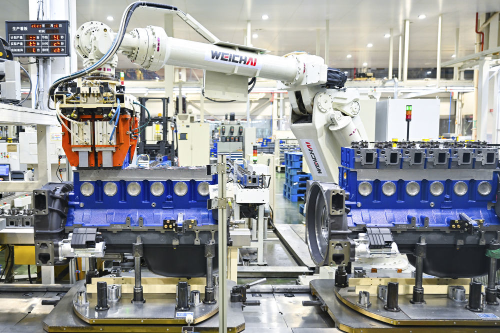 2023年11月30日，在潍柴动力股份有限公司总装生产线，机器人在装配清洁能源发动机。新华社发（孙国祥 摄）