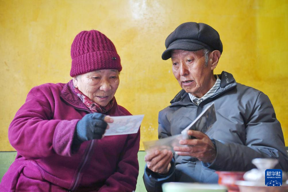 洛桑贡布（右）和老伴次仁白姆翻看老照片（3月27日摄）。新华社记者 张汝锋 摄