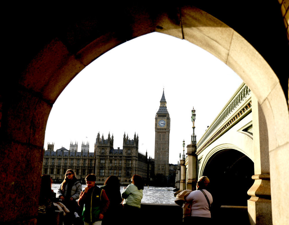 人们在英国伦敦泰晤士河边游览。对岸是伦敦地标建筑——大本钟。