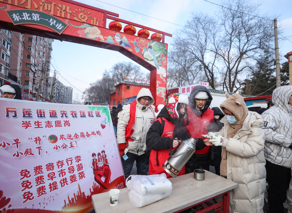 2024年1月21日,在辽宁沈阳小河沿早市,志愿者为游客提供免费热水。新华社记者 龙雷 摄