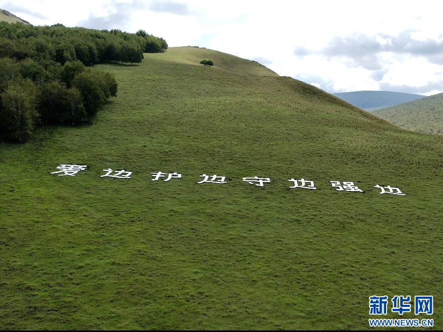 王玉发用1000余块石头在大山上堆砌出“爱边 护边 守边 强边”八个大字。新华网发（左泰 摄）