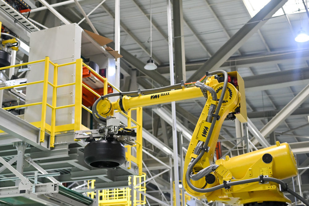 在杭州中策钱塘实业有限公司轮胎数字工厂车间，机械臂在运输轮胎半成品（7月26日摄）。新华社记者 江汉 摄