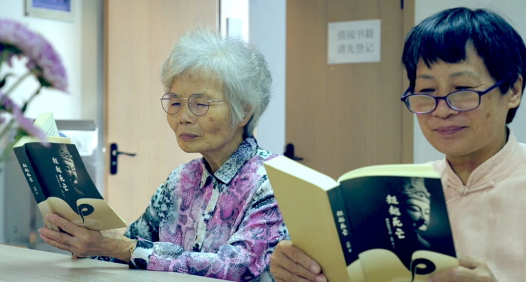 老人正在阅读《超越死亡》书籍