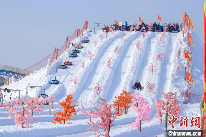 游客们在雪坡顶蓄势准备，只待飞驰而下，尽享冰雪运动带来的惊险刺激。杨辈兰 　摄