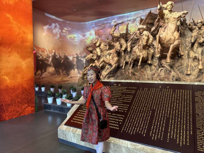6月24日，在内蒙古自治区兴安盟乌兰浩特市的内蒙古民族解放纪念馆，“小小红色宣讲员”穿戴蒙古族服饰，声情并茂地为观众讲解。中青报·中青网记者 石佳/摄