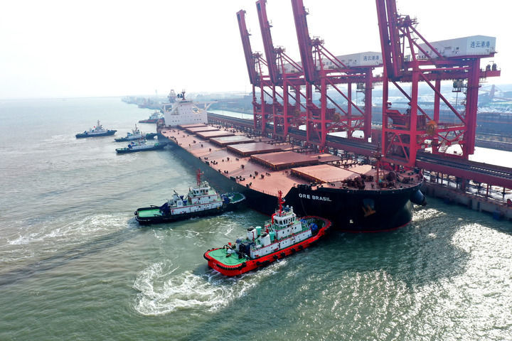 2023年12月19日,一艘满载40万吨铁矿石的“巴西矿石”轮缓缓停靠江苏连云港矿石码头卸货。新华社发(王春 摄)