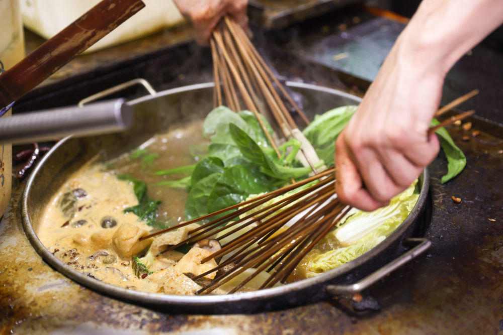 7月22日，工作人员在甘肃天水市名优小吃城的一家店铺制作麻辣烫。新华社记者 吕帅 摄