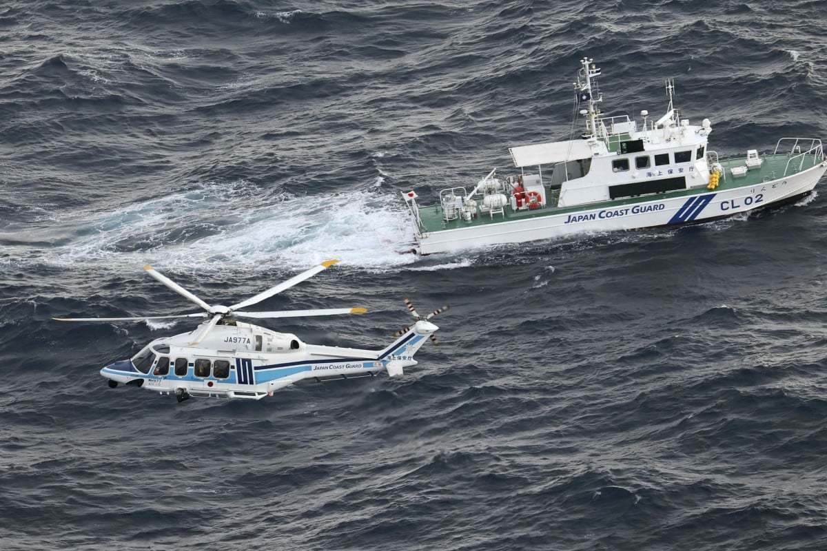 图为日本海岸警卫队巡逻船和直升机参加搜救任务。图源：日本共同社