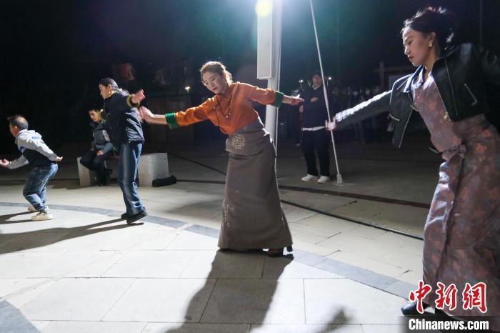 4月26日晚，拉萨柳梧新区的上班族嘎玛石努(右二)跳夜间锅庄舞。中新社记者 江飞波 摄