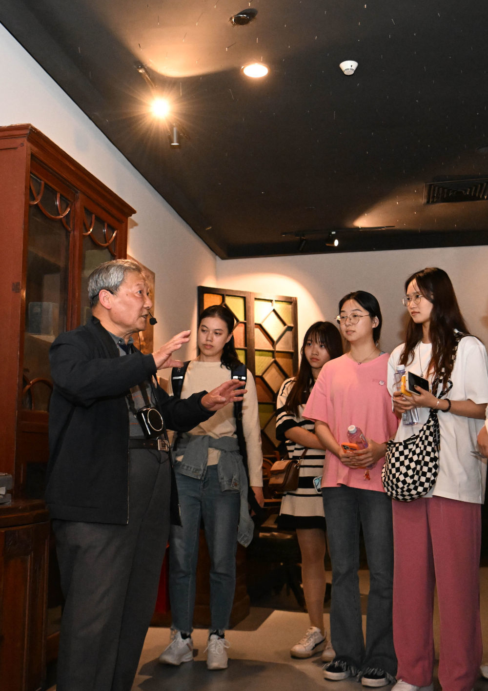 金彭育（左一）在五大道历史博物馆义务给游客讲解（4月13日摄）。