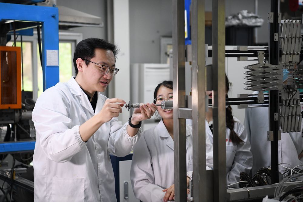 2024年4月6日，在位于安徽合肥的中国科学技术大学，安徽省先进功能高分子薄膜工程实验室团队成员朱健和（左）在和同事讨论实验设备的设计方案。