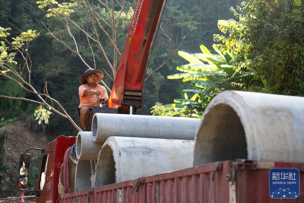 ↑8月7日，在资兴市白廊镇布田村，抢险队伍在抢修道路。新华社记者 陈思汗 摄