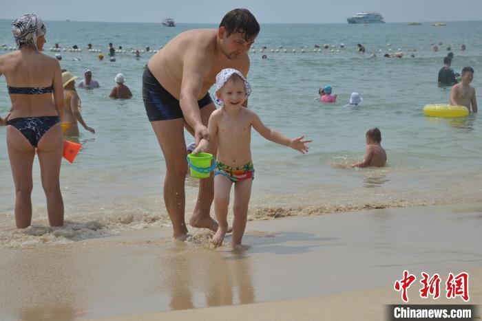 10月2日，海南三亚大东海旅游区沙滩上游人如织。图为外国亲子家庭在三亚玩海。张月和 摄