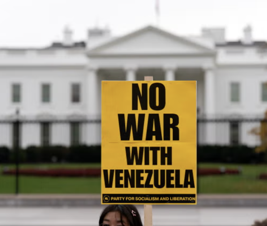 15日,一名抗议者在白宫外举着标语,反对美国对委内瑞拉发动战争。(图源:美联社)