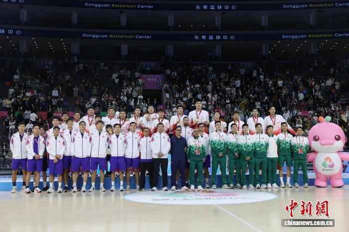 11月12日晚,第十五届全国运动会篮球项目男子成年组金牌赛在东莞篮球中心举行,广东队101比65战胜浙江队夺得金牌。图为颁奖仪式后,广东队、香港队、澳门队合影。中新社记者 盛佳鹏 摄