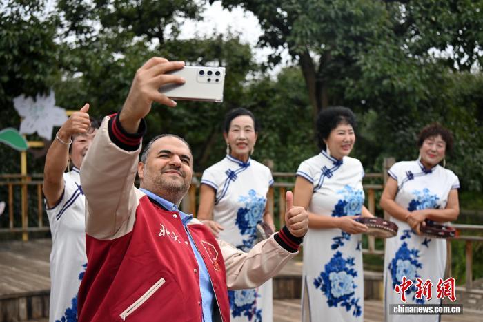 图为学员在什川镇世界第一古梨园与当地民众拍照留念　中新社记者　九美旦增　摄