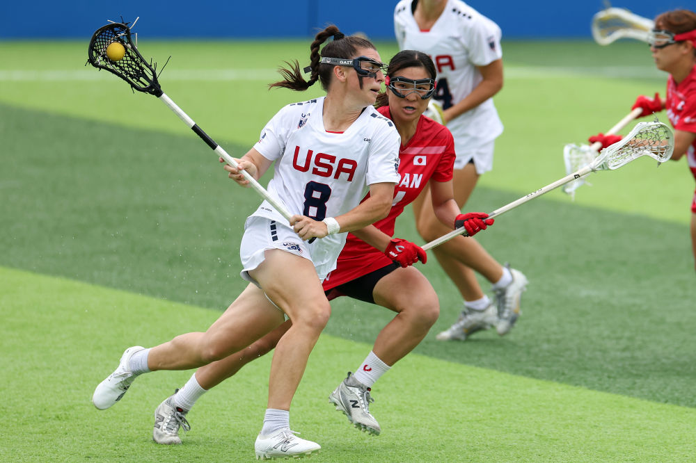 8月10日，美国队球员夏洛特·诺思（左一）在女子棍网球半决赛中进攻。新华社记者 陈斌 摄