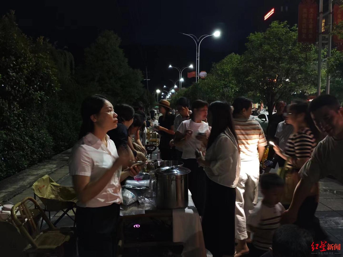 ▲灌江边,两名女孩正在售卖凉粉