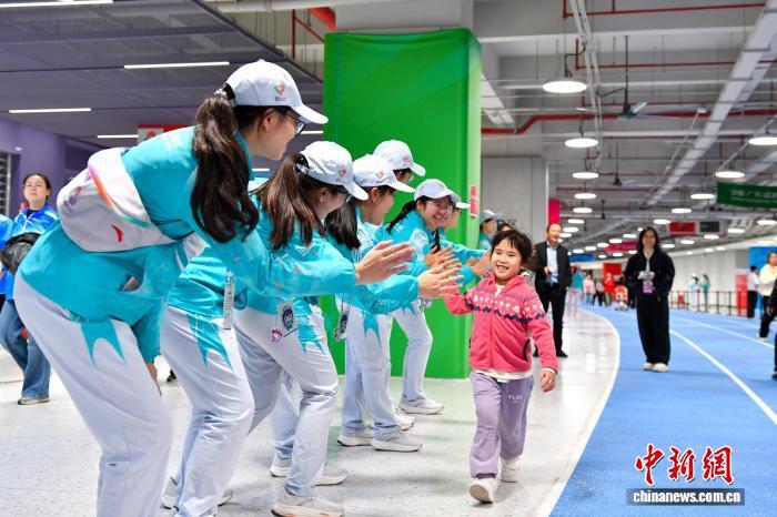 圖為中場志願者與前來觀看十五運會開幕式的小朋友擊掌。　黃焯 　攝