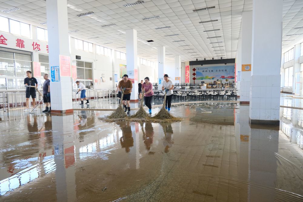 下营中学的各科老师穿着雨靴进行清淤工作。新华社记者 张宇琪 摄