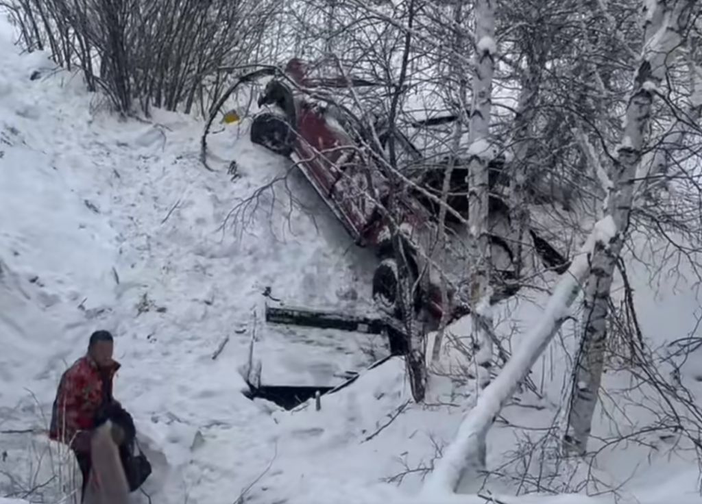 滑到路下方谷底侧翻的越野车。