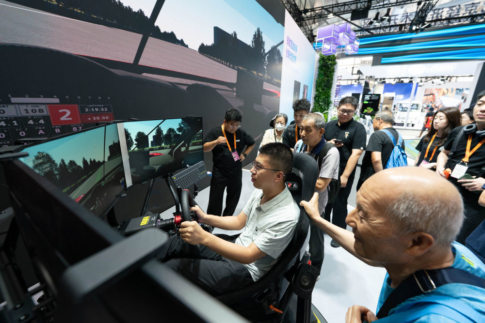 ↑ 9月11日，参观者在体验六自由度赛车模拟器。