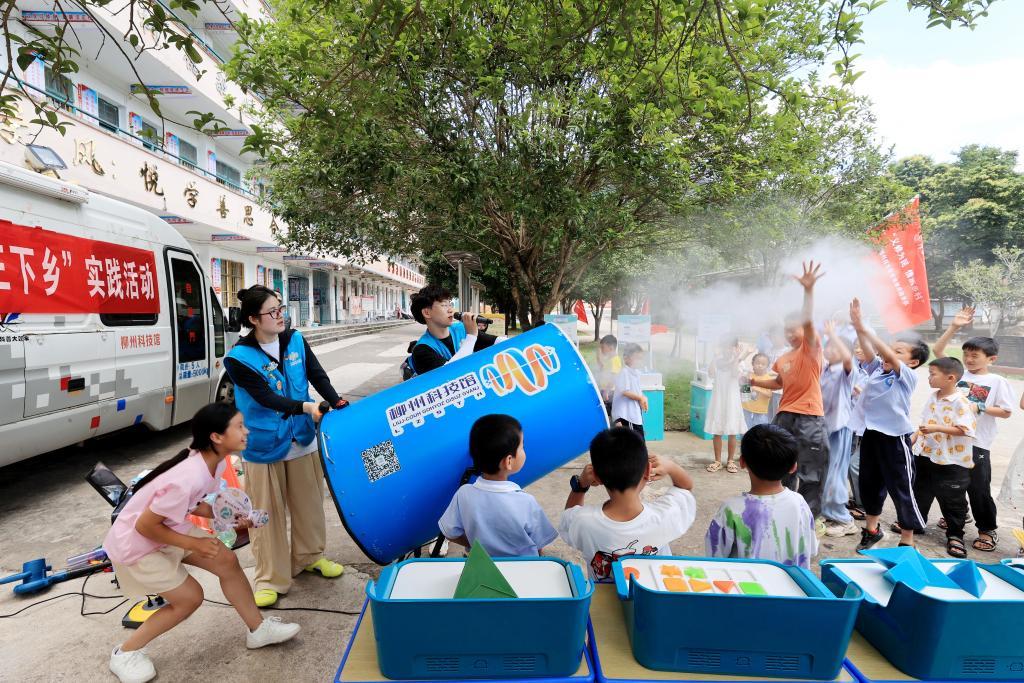 2024年7月17日，在广西柳州市融安县泗顶镇中心小学举办的柳州市科协、柳州科技馆、广西科技大学“三下乡”实践活动上，志愿者带领孩子们感受“空气炮”。新华社发（谭克兴 摄）