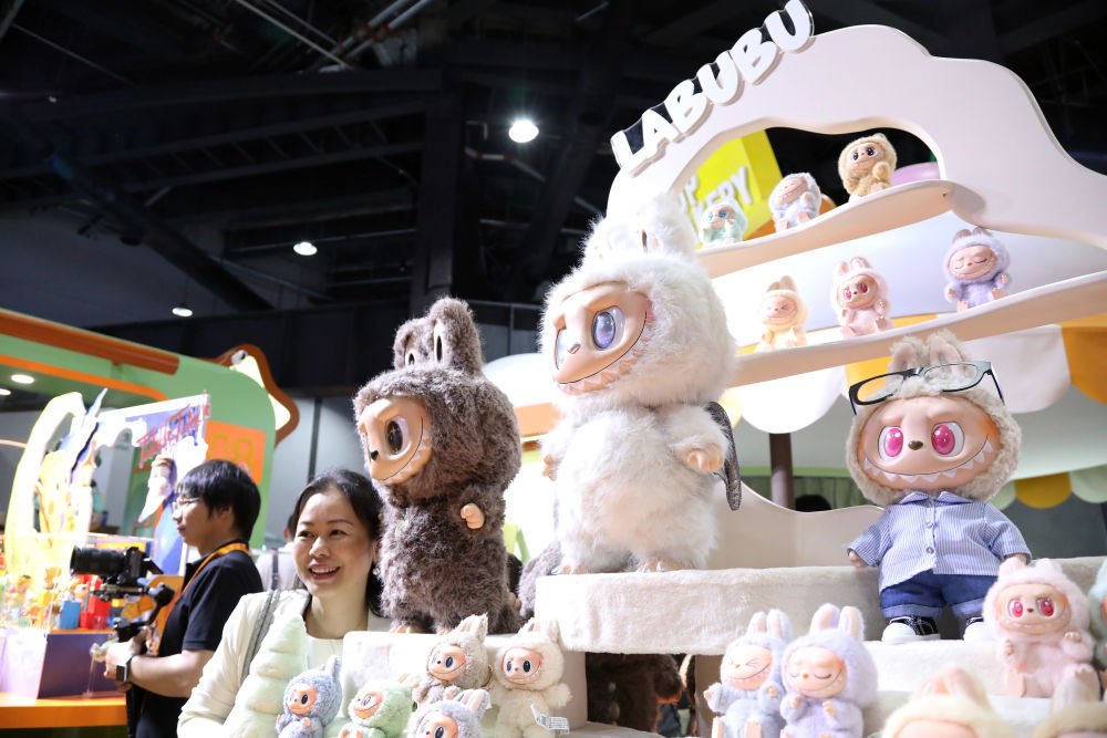 2025年9月10日，在2025年服贸会上，参会人员在泡泡玛特展台与LABUBU玩偶合影。新华社记者 侯俊 摄