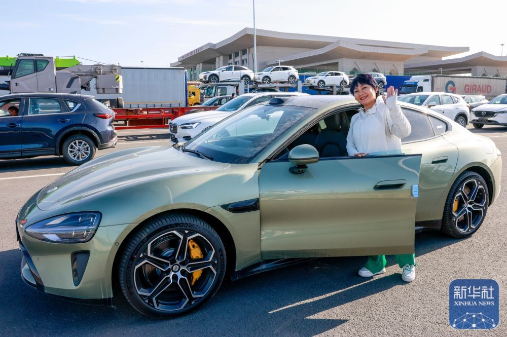 在新疆霍尔果斯公路口岸,“摆渡人”高云等待出关(5月29日摄)。她的身后是等待出口的商品车。