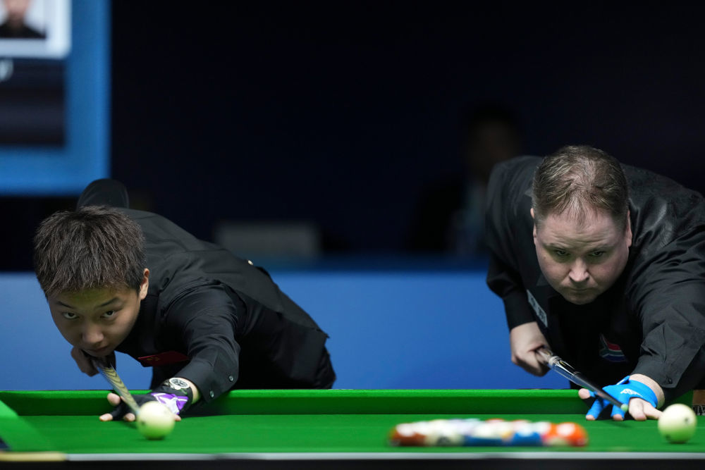 8月14日,中国选手张泰艺(左)和南非选手塞龙在2025年成都世运会台球八球混合金牌赛前开球。